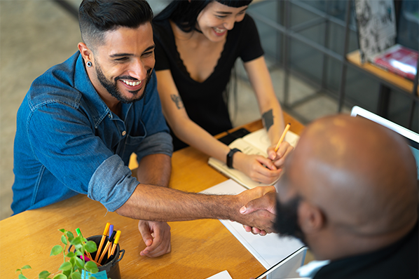 A couple shaking hands with an financial advisor