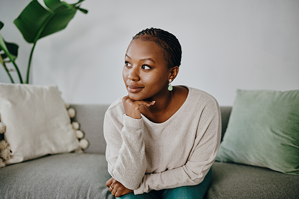 a young woman sitting on her couch looking away