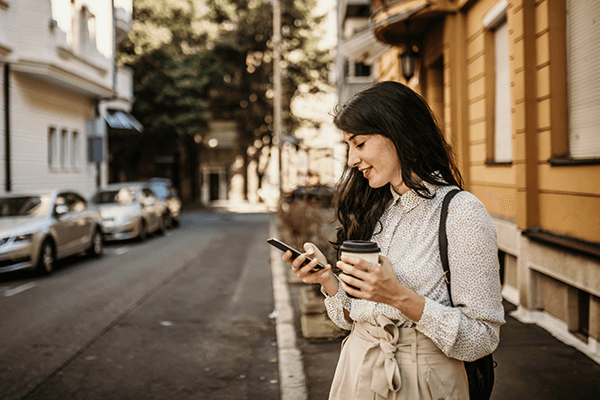 A woman looking at her phone screen on the street