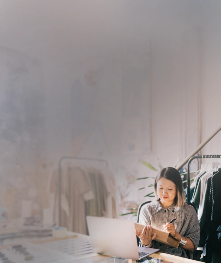 A woman writing on a retail shipping box