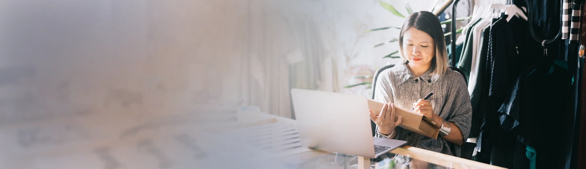 A woman writing on a retail shipping box