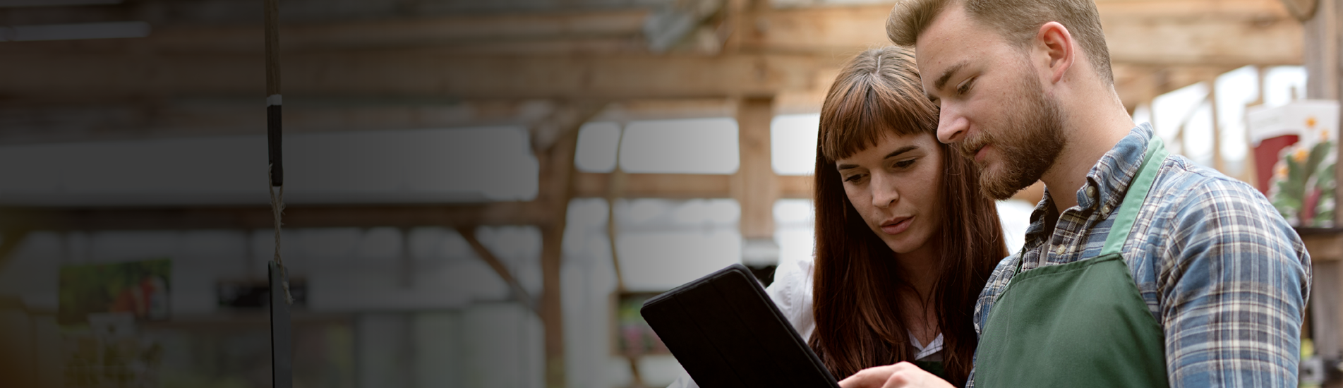 A man and woman having a discussion while looking at a tablet